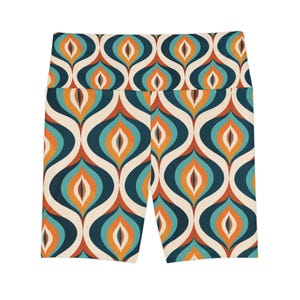 Könnte beinhalten: Hoch taillierte Sportshorts mit einem sich wiederholenden geometrischen Muster aus ineinandergreifenden Tropfenformen in Dunkelmarineblau, hellem Türkis, warmem Orange und Creme. Die Shorts haben einen breiten Bund und eine körpernahe Passform.