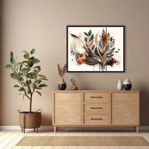 May include: A framed abstract art print with a brown, green and beige colour scheme. The print features a stylised floral design with leaves and branches. The print is hanging on a light beige wall above a wooden dresser.