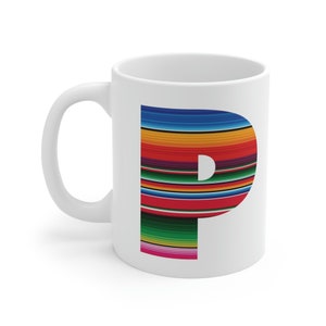 Può includere: Tazza in ceramica bianca con un design a lettera "P" colorato. La lettera è composta da strisce in tonalità di blu, arancione, rosso, verde e rosa.