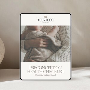 May include: A digital tablet displays a Preconception Health Checklist, with the text "Preparing for Parenthood." The image on the tablet shows a baby wrapped in a blanket. The tablet is on a white surface, next to a beige vase.