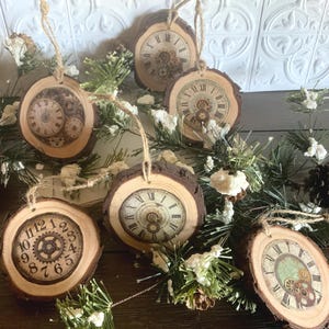 May include: Six wooden ornaments with a rustic, vintage aesthetic. Each ornament features a different clock face with Roman numerals and gears. The ornaments are decorated with a distressed white paint and are perfect for adding a touch of vintage charm to your holiday decor.