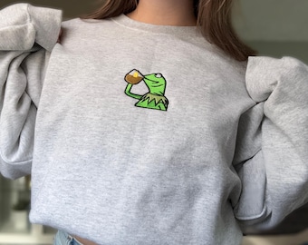 Geborduurde kikker met ronde hals nippend | Dat zijn mijn zaken niet | Grappig memecadeau