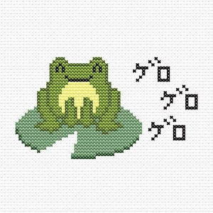 May include: A green frog with a yellow belly sits on a green lily pad. The frog is smiling and has its eyes closed. The text 'ガ' is repeated three times to the right of the frog.