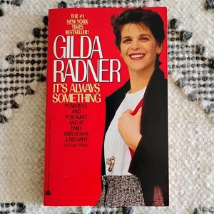 May include: A hardcover book with a red cover featuring the title "IT'S ALWAYS SOMETHING" by Gilda Radner. The cover includes a photo of Gilda Radner and text that reads "The #1 New York Times Bestseller!"