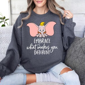 a woman wearing a sweatshirt that says embrace what makes you different