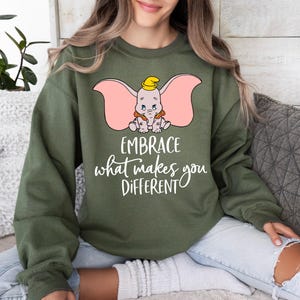 a woman sitting on a couch wearing an elephant sweatshirt