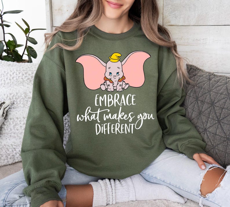 a woman sitting on a couch wearing an elephant sweatshirt