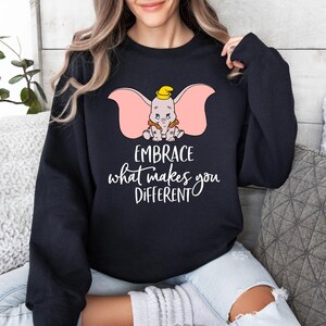 a woman wearing a sweatshirt that says embrace what makes you different