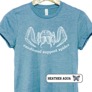 May include: A teal blue t-shirt with a white illustration of a spider and the text "emotional support spider".