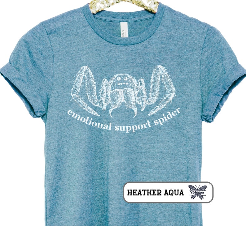 May include: A teal blue t-shirt with a white illustration of a spider and the text "emotional support spider".