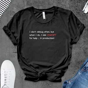 Puede incluir: Camiseta negra con texto blanco que dice "No depuro a menudo, pero cuando lo hago, le pido ayuda a ChatGPT... ¡en producción!"