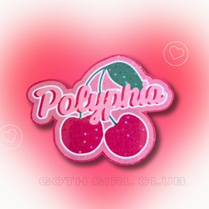 May include: Pink glitter sticker with a pair of cherries and the word "Polyphonia" in a retro font. The sticker has a pink background with white outlines and holographic stars.