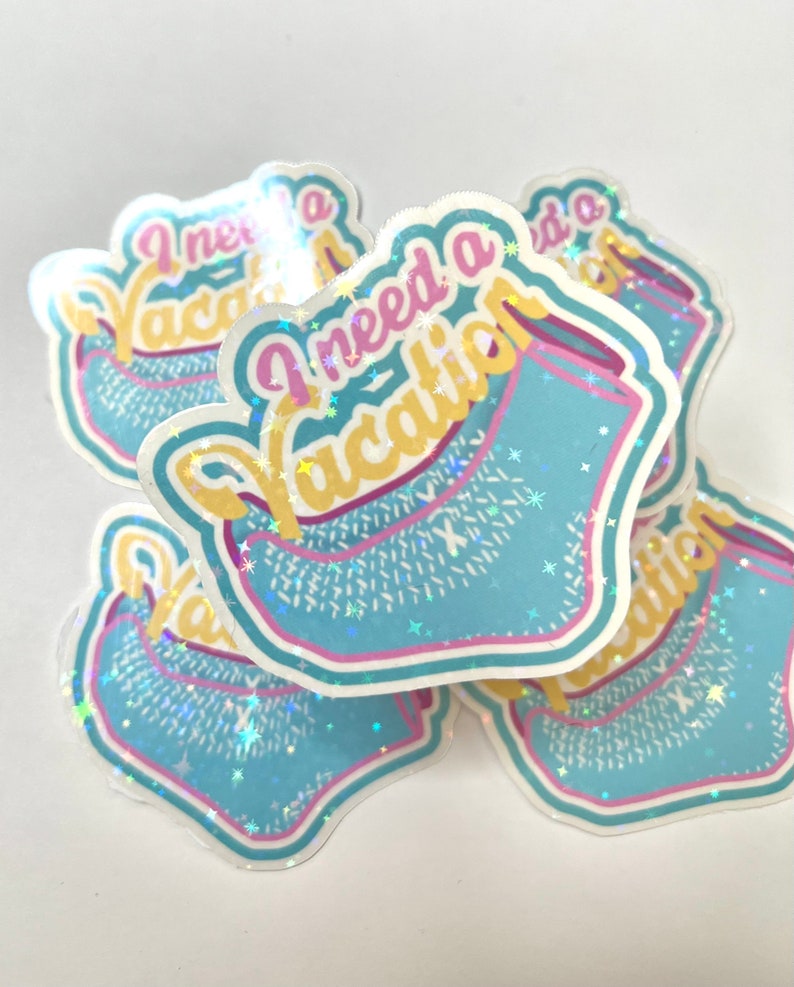 May include: Four iridescent blue and yellow stickers with the text "I need a vacation" in pink and yellow letters. The stickers have a glittery finish and a blue and yellow design that resembles a beach towel.