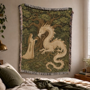 May include: A woven throw blanket featuring a detailed illustration of a long-haired figure in a light-colored gown offering a bowl to a large, cream-colored dragon. The scene is set in a dark green forest with a large tree, finished with fringe.