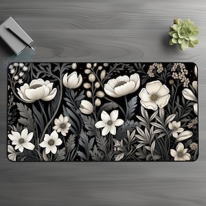 May include: Black and white floral design mousepad with white flowers on a dark background.