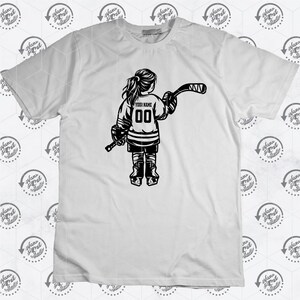 K&ouml;nnte beinhalten: Schwarzwei&szlig;es Grafikdesign eines Hockeyspielers, der ein Trikot mit dem Text "YOUR NAME" und der Nummer "00" tr&auml;gt. Der Spieler h&auml;lt einen Hockeyschl&auml;ger und ist vom Betrachter abgewandt.