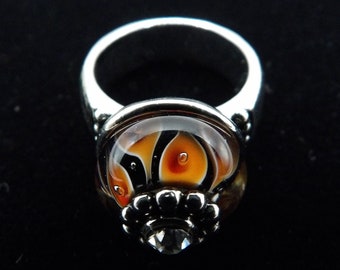 Orange, red, black, and white flame lampworked glass rondelle on silver toned rhodium plated ring size 7