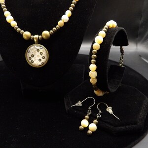Conjunto de collar, pulsera y pendientes de nácar y oro envejecido