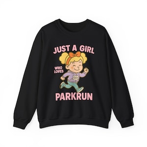 Op de afbeelding: Zwart sweatshirt met een cartoonillustratie van een rennend meisje. De tekst luidt "JUST A GIRL WHO LOVES PARKRUN" in roze. Het meisje draagt een paarse hoodie, een turquoise broek en een startnummer.