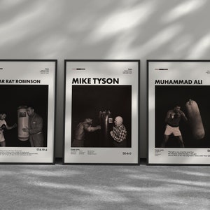 Peut inclure: Trois affiches encadrées noires avec du texte blanc et des photos en noir et blanc de boxeurs célèbres. Les affiches présentent Sugar Ray Robinson, Mike Tyson et Muhammad Ali. Chaque affiche comprend le nom du boxeur, son palmarès et une citation.