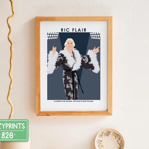 May include: A framed print of a wrestler in a black and white wrestling outfit with the text "RIC FLAIR" and "IN ORDER TO BE THE MAN, YOU HAVE TO BEAT THE MAN".