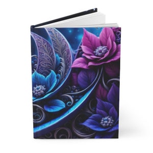 Puede incluir: Diario de tapa dura con un diseño floral vibrante. La portada muestra flores estilizadas moradas y azules con detalles intrincados sobre un fondo azul oscuro. El diario tiene lomo negro y páginas blancas.
