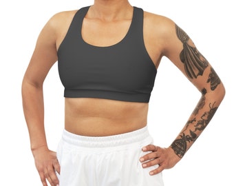 May include: A charcoal gray sports bra with a racerback design. The bra is made of a stretchy, comfortable fabric and has a scoop neck.