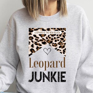 May include: Gray sweatshirt with a leopard print design and the text "Leopard is the new black" and "Leopard Junkie".