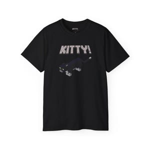 Könnte beinhalten: Schwarzes T-Shirt mit einer pixeligen schwarzen Katze und dem Text "KITTY!" in Weiß.