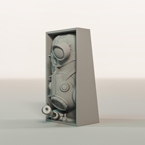 May include: A gray, futuristic gas mask with multiple circular and oval components, housed within a matching gray rectangular box. The mask has a complex design with various tubes and vents, suggesting a protective or industrial function. The overall aesthetic is modern and mechanical.