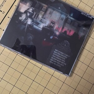 May include: A black CD case with a white and red house on the front. The title "SPVCXXGHXZTPVRRP" is printed in white on the front of the case. The text "CONGER BY VILLE KOSTINE" is printed in white on the right side of the case. The back of the case has black text on a black background.