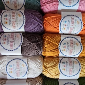 May include: A collection of twelve skeins of 100% cotton Chunky Thread by Lori Holt of Bee in my Bonnet, arranged in a grid. Each skein features a white paper label with blue scalloped edges, displaying the text Chunky Thread and floral icons.