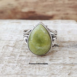 May include: A teardrop-shaped green gemstone ring set in silver with a twisted band.