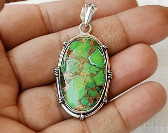 May include: Oval shaped pendant with a green and gold turquoise stone set in sterling silver.