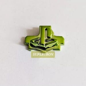 May include: A green plastic PlayStation button with the PlayStation logo in the centre.