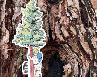 Könnte beinhalten: Ein Aufkleber mit einem Astronauten, der einen Baum umarmt, mit dem Text "EASY PEEL" und einer Website-Adresse. Der Aufkleber ist auf einem Baumstamm mit einem großen Knoten angebracht.