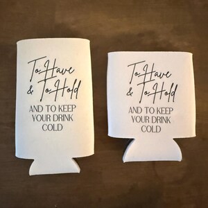 May include: Two white foam beverage insulators of different heights, each featuring black printed text that reads: To Have & To Hold AND TO KEEP YOUR DRINK COLD. The taller sleeve is designed for slim cans, while the shorter sleeve fits standard cans.