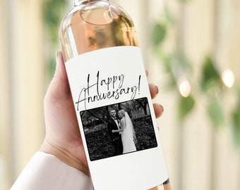 May include: A white wine bottle with a label that says "Happy Anniversary!" and features a black and white photo of a couple.