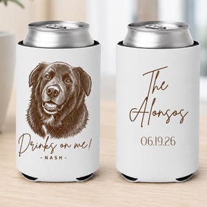 May include: Two white foam can coolers with brown ink designs. One features a brown sketch of a dog with the text "Drinks on me! - NASH -". The other displays the text "The Alonsos" in script above the date "06.19.26" in a simple brown font.
