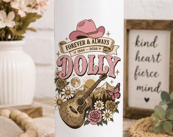 May include: A white cylindrical tumbler with a metal straw featuring a graphic of a pink cowboy hat, an acoustic guitar, flowers, a butterfly, and mountains. The text reads FOREVER & ALWAYS 1946-2026 and DOLLY in large pink letters.