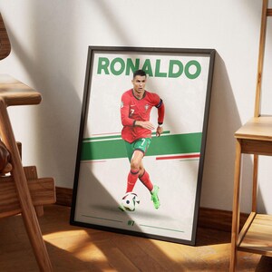 May include: Framed poster featuring soccer player Ronaldo in a red jersey with green shorts, dribbling a soccer ball. The poster has the name "RONALDO" in large green letters at the top and the number "7" on the jersey.