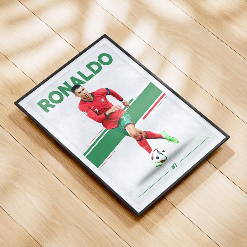 May include: Framed print featuring Cristiano Ronaldo in a red and green soccer uniform. The word "RONALDO" is printed in large green letters at the top. The player is kicking a soccer ball, with the number 7 visible.