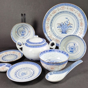 Könnte beinhalten: Ein Set aus blauen und weißen Porzellan-Teetassen, Untertassen und einer Teekanne mit Blumenmuster. Das Set enthält auch eine kleine Schüssel und einen Löffel.