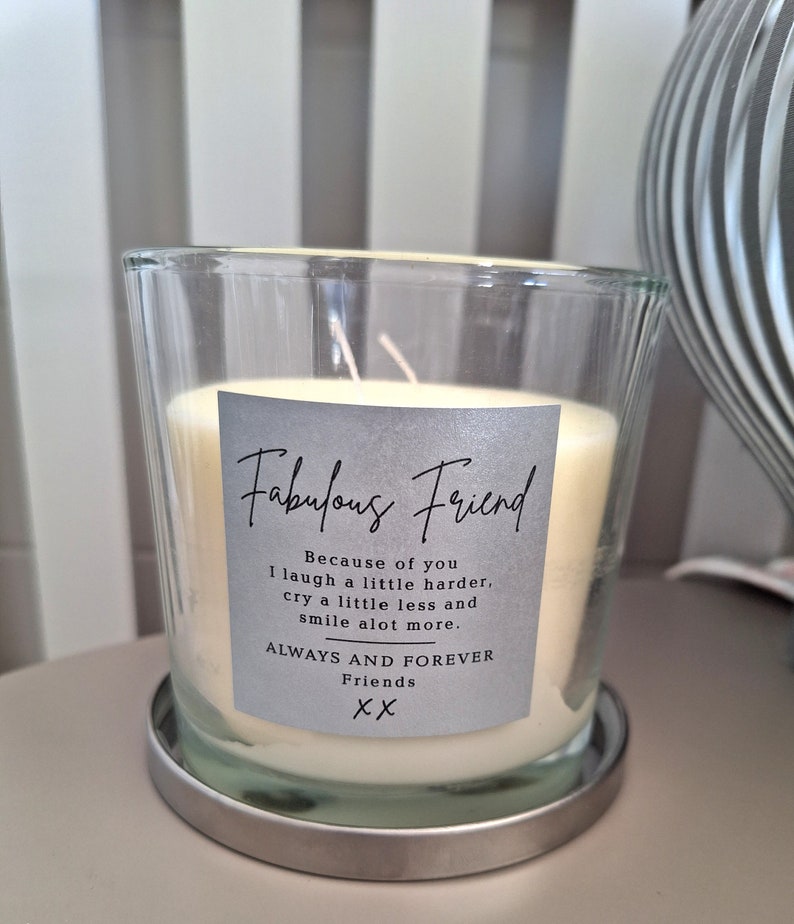 May include: A clear glass candle jar with a silver lid and a gray label that reads "Fabulous Friend" with the text "Because of you I laugh a little harder, cry a little less and smile alot more. ALWAYS AND FOREVER Friends XX".