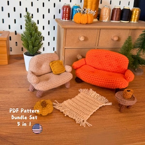 May include: Crochet amigurumi furniture set with a peach colored couch, an orange couch, a small rug, a side table, and a small pumpkin. The furniture is arranged on a wooden surface. The text "PDF Pattern Bundle Set 5 in 1" is visible in the image.