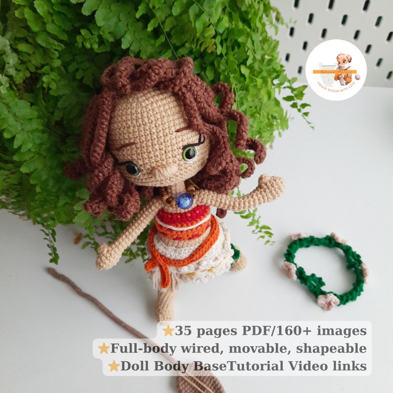 May include: A crocheted doll with brown curly hair, green eyes, and a necklace with a blue gem. The doll wears a white and orange dress and has a green and pink floral crown. The image includes text about the doll's features.