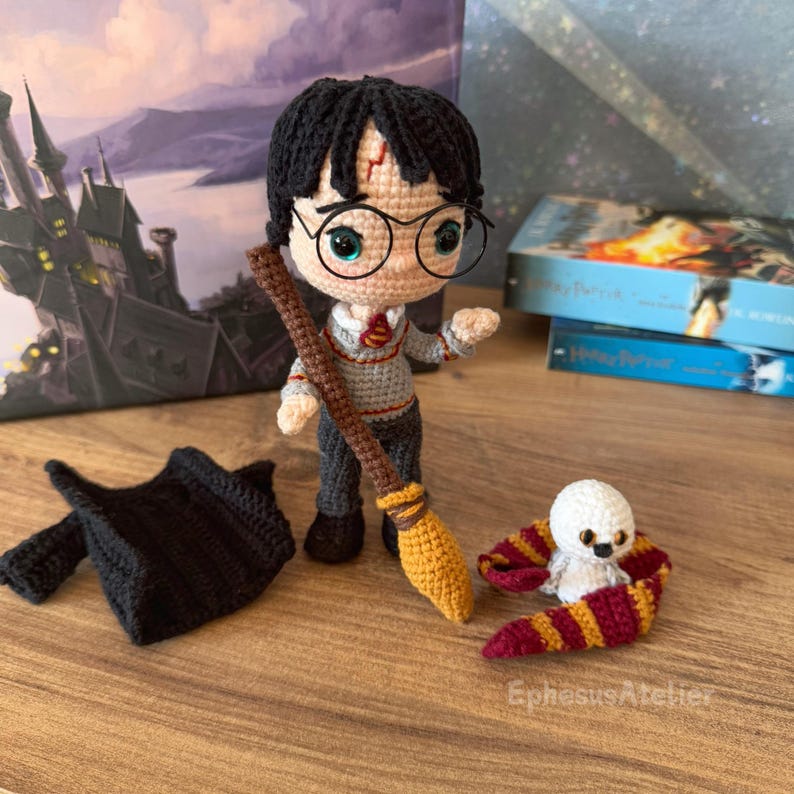 Pode incluir: Boneca Harry Potter de croch&ecirc; com uma capa preta, uma varinha marrom, uma vassoura amarela e uma coruja Hedwig branca com uma echarpe vermelha e dourada.