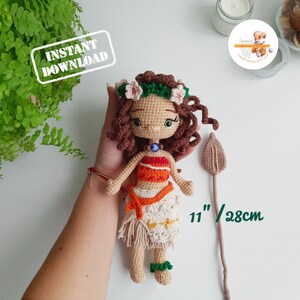 May include: Crocheted doll with brown curly hair, a floral crown, and a spear. The doll wears a red and orange top, a cream-colored skirt, and green bracelets. The doll is 11 inches (28cm) tall. Text on the image says "INSTANT DOWNLOAD".