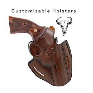 Op de afbeelding: Een bruin leren holster met een decoratief schedel-embleem van een stier, gecombineerd met een revolver met houten handvat. De tekst "Customizable Holsters" staat boven de objecten. Het holster heeft gestikte details en een uitsparing voor de loop.