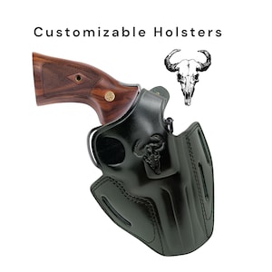 Op de afbeelding: Zwarte leren holster met een revolver en een schedel van een stier. De tekst "Customizable Holsters" staat bovenaan. De revolver heeft een houten handvat. De holster heeft een decoratief ontwerp van een schedel van een stier.